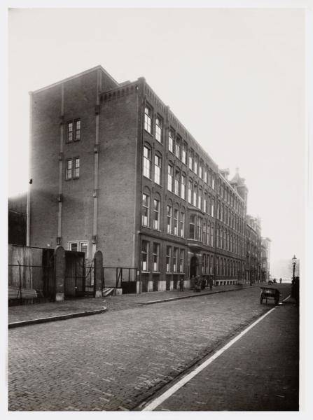 De Industrieschool 1n 1934 Marcusstraat 2-54 (v.l.n.r.), gezien in oostelijke richting naar de Weesperzijde en de Amstel, met links op nummer 54 de Industrieschool voor Naaisters.<br />De foto is van (gemaakt door) Vereenigde Fotobureaux N.V. (fotograaf).<br />Bron: Beeldbank, Stadsarchief Amsterdam. 