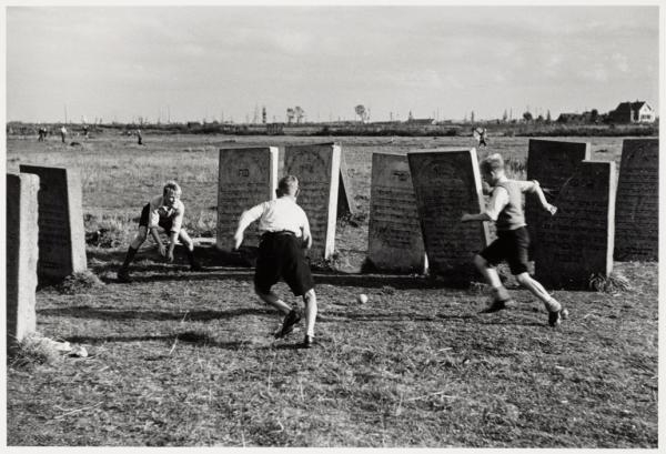 Joodse begraafplaats Zeeburg in het tegenwoordige Flevopark. Voetballende jongens tussen de zerken. Deze foto dateert van 1947 en is gemaakt door de fotograaf E. van Moerkerken. Bron: Beeldbank Stadsarchief Amsterdam. 