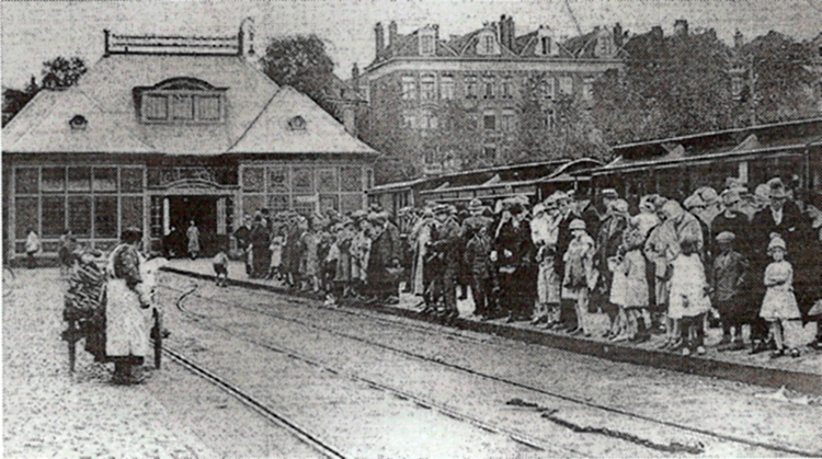 De passagiers wachten op de tram naar Laren. Op de voorgrond ligt de ketting om de wagens voorbij het wissel te trekken. .<br />Foto: Daar reed toen de Gooische. 