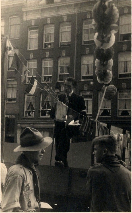 Bevrijdingsfeest 1945 - 1945  <p>Achter de microfoon mede-organisator van het feest drogist R. van Eck ter hoogte van Dapperstraat 91.<br />
<em>Foto: Ruud van Eck</em></p>