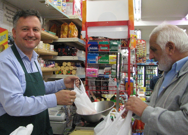 Huseyin achter de kassa in zijn winkel (foto: 2009) 'ook specerijen en blikgroenten dienen halal-waardig te zijn in mijn winkel' 