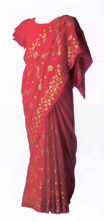 Sari Dit is de rode met goud bewerkte sari waarin Geeta in 1978 in Suriname trouwde. De sari is door haar ouders speciaal gekocht voor haar bruiloft. Sari's komen oorspronkelijk uit India. De kleur rood staat voor reinheid. Geeta draagt sari's thuis, op feesten en tijdens tempelbezoek.<br />Geeta Sowdagar-Pantjoe schonk haar huwelijkssari aan het Amsterdams Historisch Museum. De sari werd vertoond tijdens de tentoonstelling 'Oost, Amsterdamse buurt' (10 oktober 2003 t/m 29 februari 2004) en maakt nu deel uit van de museumcollectie (AHM). 