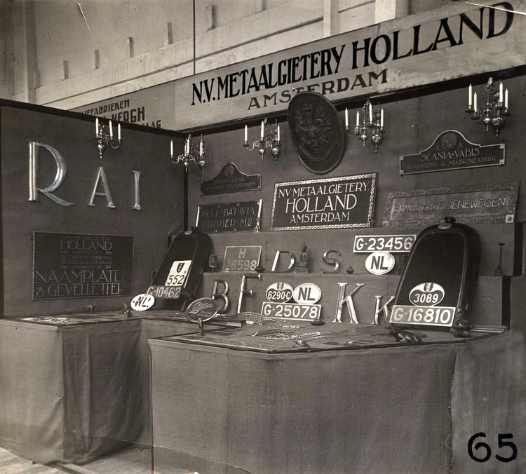 RAI-autotentoonstelling: Stand van de N.V. Metaalgieterij Holland met nummerplaten. Amsterdam, 1924. .<br />Foto: Geheugen van Nederland 