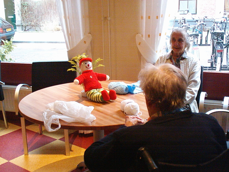 Oude vrouw met pop Recente foto, lid van de vrouwenclub Kastanjehof Een lid van de vrouwenclub aan het Kastanjehof met een gebreide pop (anno 2005). 