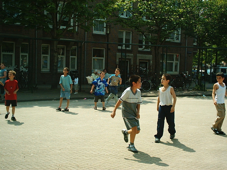  Ridvan (3e van links) speelt met zijn vrienden op het Steve Bikoplein, 2003. 