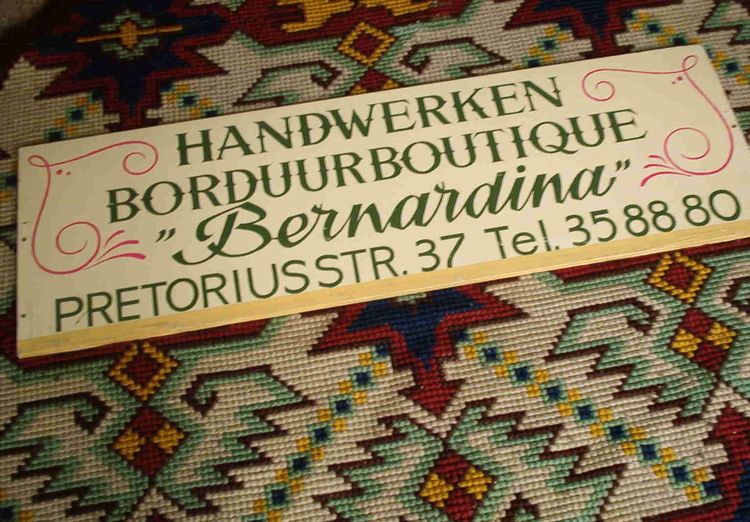  Het uithangbordje van Dineke's borduurboutique.<br />Dineke Rizzoli schonk het uithangbord aan het Amsterdams Historisch Museum. Het bord werd vertoond tijdens de tentoonstelling 'Oost, Amsterdamse buurt' (10 oktober 2003 t/m 29 februari 2004) en maakt nu deel uit van de museumcollectie (AHM). 