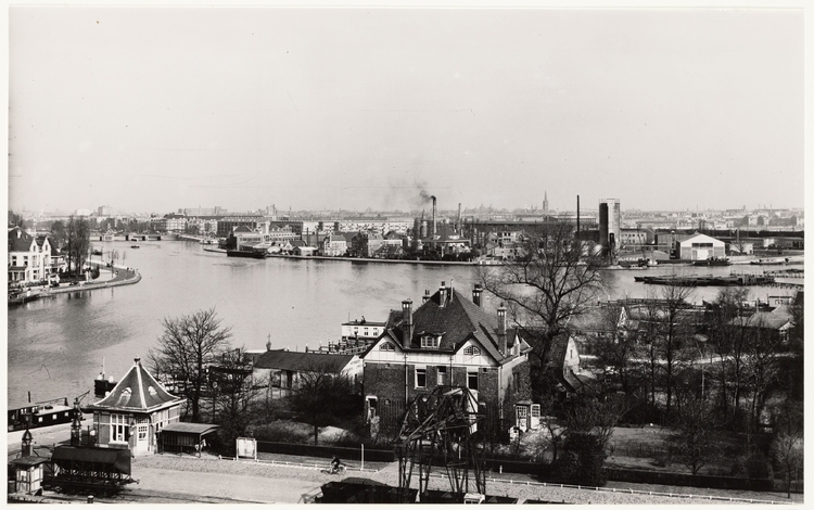 Het terrein van de Zuidergasfabriek in 1954, gezien naar de Amstel en de Amsteldijk (links) en de Omval (rechts). Op de voorgrond in het midden de Ingenieurswoning, Korte Ouderkerkerdijk 45. Foto Rinus Knopper. Collectie Stadsarchief Amsterdam.  